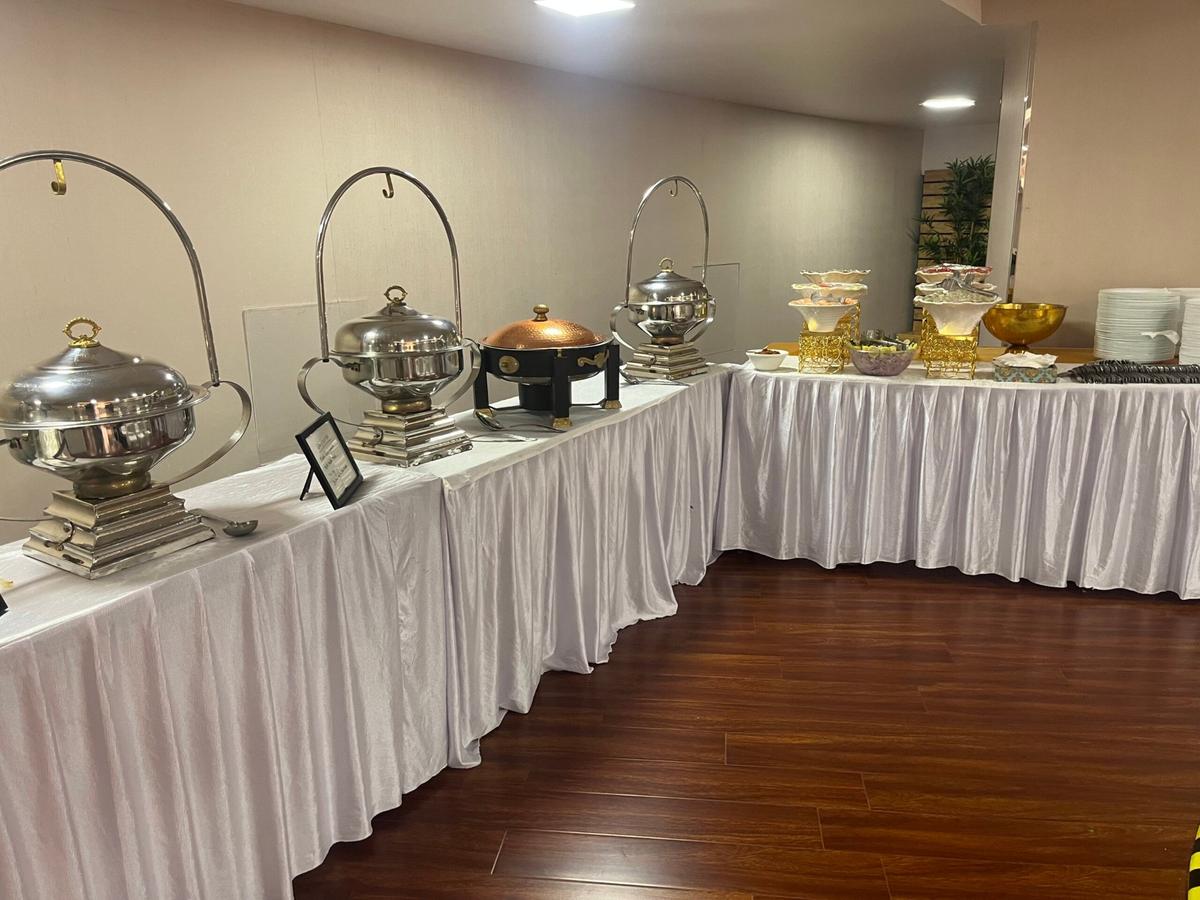 Silver and copper chafing dish buffet on white drapery